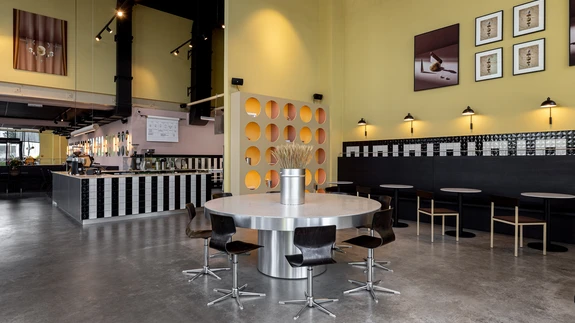 Kohviku ruumid avaldavad muljet oma pea seitsme meetrini kõrguvate lagede, avaruse ning võikollaste seintega. Suured aknad avavad vaate vilkale Tööstuse tänavale.