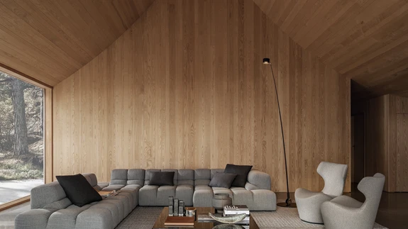 Katuse ekspressiivsest vormist tulenevalt ulatub elutoa kõrgus kohati kuue meetrini. Hallides toonides sisustus kõlab kokku akende taga laiuva kaljumaastikuga. Patricia Urquiola diivan Tufty-Time ja Naoto Fukasawa tugitoolid Papilio.