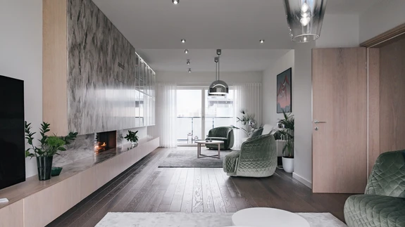 Läbi maja ulatuvas elutoas on kaks istumisgruppi, mida ehivad Moroso Redondo tugitoolid ja diivan. Valgustid on Tom Dixonilt, vaibad Casa Stuudiost ja diivanilaud Eesti disainerilt Aap Piholt ning firmalt Meridiani. 