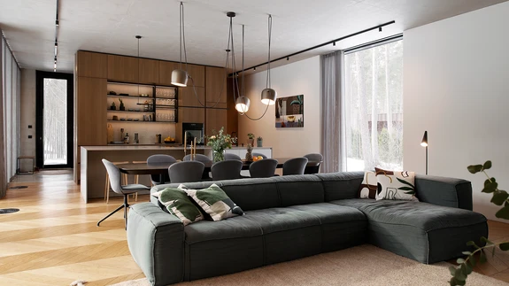 Betooni külmust aitavad pehmendada mugav sohva, tekstiilid ja soojad puidutoonid. Avatud, heledat puitu ja tehiskivi kombineeriv minimalistlik köök telliti Arensist.