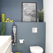 Sinakashalli tualetti toob särtsu kollane värv. Vanapaberist tehtud paberihoidja ja plakat esindavad Rento Designi toodangut.