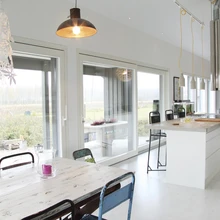 Avatud köögi-elutoa suured aknad toimivad samas liugustena, avanedes majatagusele loodusmaastikule. Suvel pikeneb neid avades siseruum terassile.