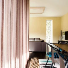 Loodus oma valguse ja varjudega tungib suurte akende kaudu tuppa.