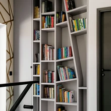 Teise korruse trepihall täidab ka väikese raamatukogu rolli, asümmeetriline riiul on dialoogis tapeedimustriga.