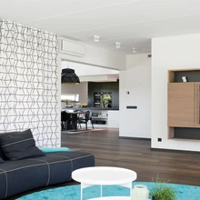 Endise basseiniruumi asemele sisustati mõnus elutuba. Klaasseinte ja küllaltki madala laega ruum mõjub koduselt ning pehmelt tänu kaunitele tekstiilidele. Ümmargune vaip telliti tekstiilikunstnik Annike Laigolt. Suur diivan pärineb Itaalia tootjalt B&B.