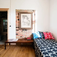 Üks esimese korruse kolmest toast. Osaliselt eksponeeritud tellissein mõjub värskelt valge lubikrohvitud seina taustal. Elevantidega voodipesu Elefantti pärineb Finlaysonilt.