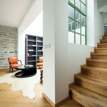 Tänu avatud katusealusele ning lisavalgust toovatele katuseakendele mõjub elutuba õhurikka ja helgena. Suur ruum kannab hästi välja massiivse nahkmööbli ning jässakale puutüvele toetuva klaasplaadiga diivanilaua.