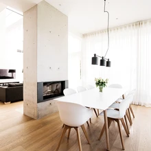 Kahepoolne kamin jaotab suure ruumi elu- ja söögitoatsooniks. Betoonist küttekolle on ühtlasi osa eramu konstruktiivsest lahendusest.