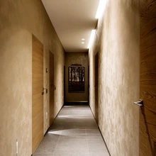 Maja selgroona kulgev pikk koridor mõjub rahulikult tänu peidetud ukseliistudele ja summutatud toonivalikule.