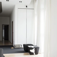 Kõrgete kapiuste taha jäävad sisseehitatud garderoobid, mis rõhutavad puhast ja rahulikku ruumimuljet.