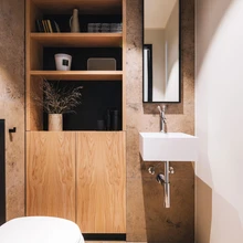 Loodustoonid ja kaunid materjalid väikeses tualettruumis.