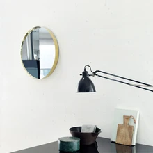 Messingraamis olev ümar peegel on disainer Iina Vuorivirra looming. Nõud laual pärinevad Artektist.